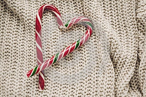 Stylish christmas flat lay. peppermint candy cane in heart shape