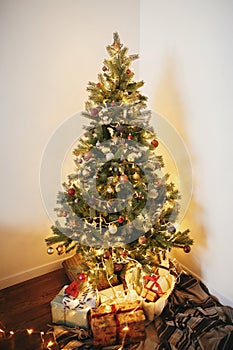 Stylish christmas gift boxes under beautiful christmas tree with