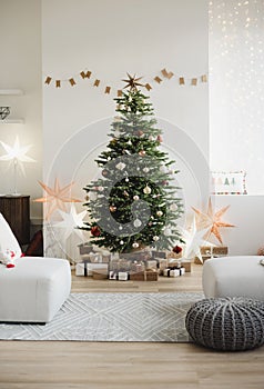 Stylish christmas interior with christmas tree, stars, gifts and decoration. Minimal xmas interior design template