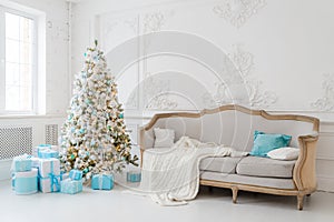 Stylish Christmas interior with an elegant sofa. Comfort home. Presents gifts underneath the tree in living room