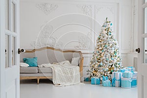 Stylish Christmas interior with an elegant sofa. Comfort home. Presents gifts underneath the tree in living room