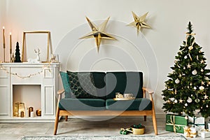 Stylish christmas living room interior with green sofa, white chimney, christmas tree and wreath, stars, gifts and decoration.