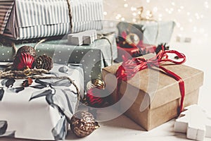 Stylish christmas wrapped presents with ornaments and lights on