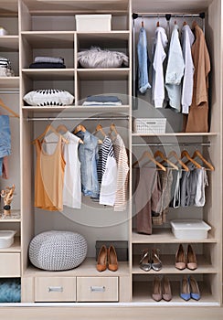 Stylish clothes, shoes and home stuff in large wardrobe