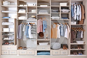 Stylish clothes, shoes and home stuff in large wardrobe photo