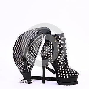 Stylish Clubbing heel boots shoes and clutch in white space. Minimal still life scene. Sale and shopping trendy concept