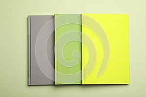 Stylish color notebooks on green background