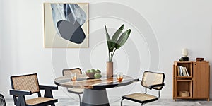 Stylish composition of dining room interior with design table, modern chairs, decoration, tropical leaf in vase, fruits.