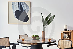 Stylish composition of dining room interior with design table, modern chairs, decoration, tropical leaf in vase, fruits, abstract.