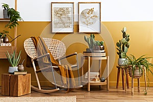 Stylish composition of living room interior with design rattan armchair, two mock up poster frames, plants, cube.