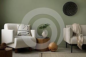 Stylish composition of living room interior with green wall, grey sofa with pillow. White armchair with brown pilow, wooden coffe