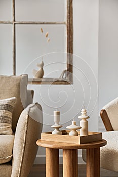 Stylish composition of modern living room interior details. Creative handmade candles on the wooden coffee table. Home staging.