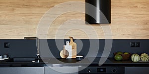 Stylish composition of modern small kitchen interior. Black kitchen workspace with  kitchen accessories.