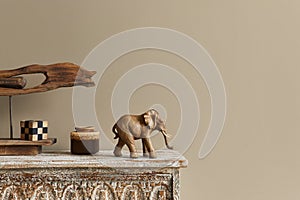 Stylish composition at moroccan interior with wooden shlef, cube, design elephant figure and decoration in modern home decor.