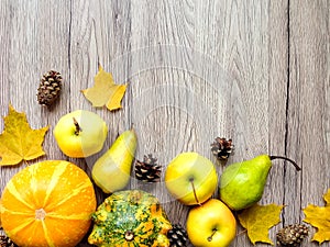 Stylish composition of pumpkins, autumn leaves and cones. Top view on wooden background. Autumn flat lay