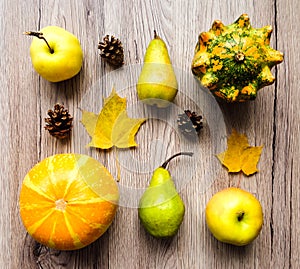 Stylish composition of vegetables, fruits, autumn leaves, cones. Top view on wooden background. Autumn flat lay