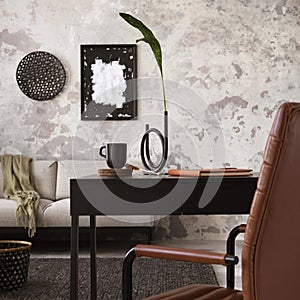 The stylish compostion at concrete living room interior with design gray sofa, brown armchair, dark desk and elegant personal photo
