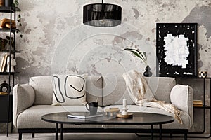 The stylish compostion at living room interior with design gray sofa, armchair, black coffee table, lamp and elegant personal photo