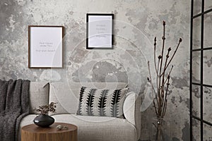 The stylish compostion at living room interior with design gray sofa, coffee table, plant, hanger, lamp and elegant personal