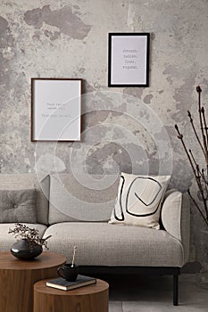 The stylish compostion at living room interior with design gray sofa, coffee table, posters and elegant personal accessories. Loft photo