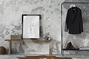 The stylish compostion at living room interior with mock up, concrete wall, bench, hanger with clothes and elegant personal photo