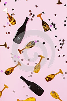 Stylish confetti in black and gold colors on pink background. Festive concept.