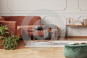 Stylish copper colored coffee table in front of comfortable corner sofa