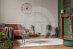 Copper colored coffee table in front of comfortable corner sofa in trendy living room