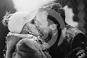 Stylish couple kissing in wooden cabin on background snowy woods