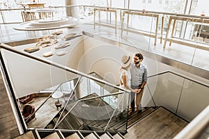 Stylish couple look at each other on stairs in restorant