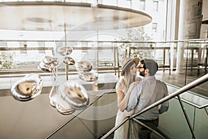 Stylish couple look at each other on stairs in restorant