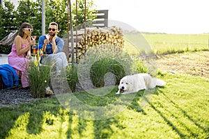 Stylish couple spend summer time with dog at the backyard