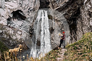 Stylish couple at the waterfall. A man and a woman traveling in the Caucasus. A couple in love is traveling in Russia.