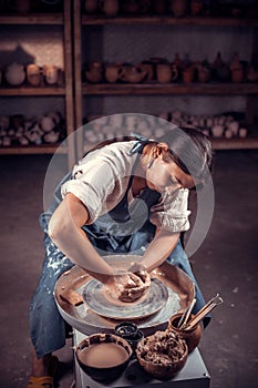 Stylish craftsman demonstrates the process of making ceramic dishes using the old technology. Folk handicraft.