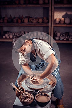 Stylish craftsman demonstrates the process of making ceramic dishes using the old technology. Folk handicraft.