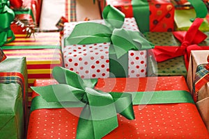 Stylish creative presents in colored paper decorated with red, green satin ribbon bows