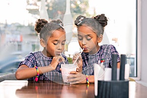 Stylish cute siblings drinking cocktail together waiting for their parents