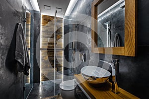Stylish dark bathroom interior with shower.