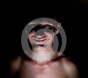 Stylish dark portrait of caucasian man who smiles like a mad or crazy