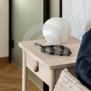 Stylish decorations on wooden bedside table, close-up