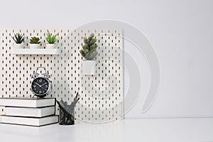 Stylish desk interior with White table background with plant and leaves. Modern home office interior