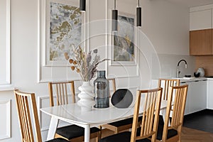 Stylish dining area next to simple kitchen