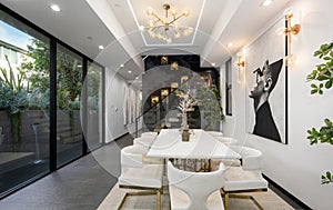 Stylish dining living room with rug, chairs, and artwork on the wall