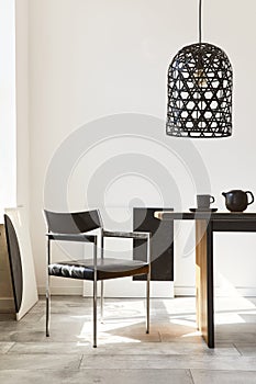 Stylish dining room interior with design wooden family table, black chairs, teapot with mug, mock up art paintings on the wall.