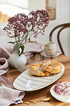 Stylish dining table composition with elegant tableware and beautiful kitchen and personal accessories. Beauty in the details.