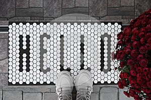 Stylish door mat with word Hello, shoes and beautiful flowers on stairs, flat lay