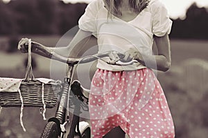 Stylish dressed girl rides on an old bicycle with a retro effect