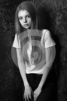 Stylish dressed stunning woman posing in a dark room