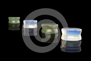 Stylish ear plug isolated on black glass