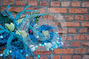 Stylish easter bouquet in blue tones over brick wall background, selective focus, copy space